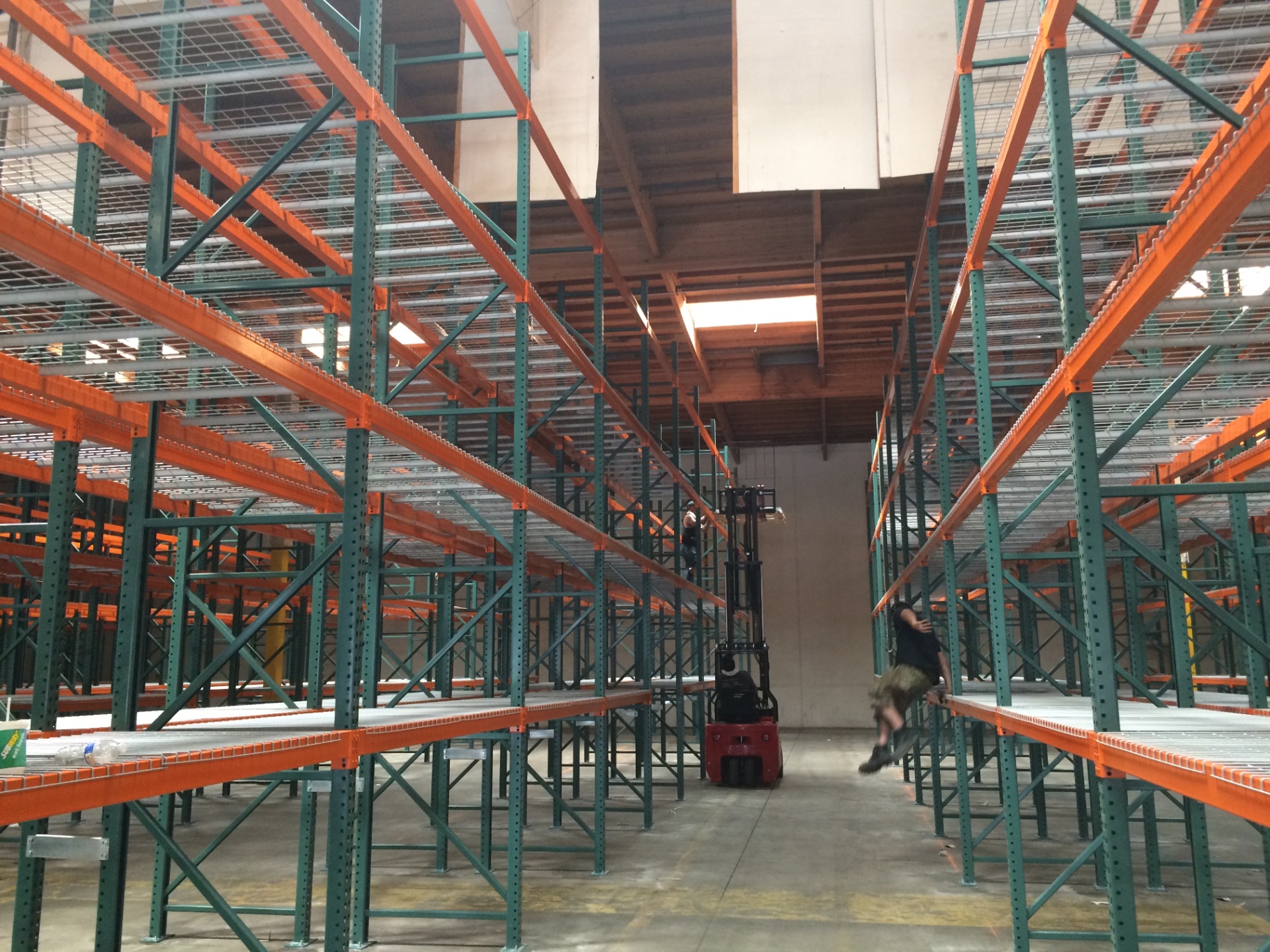 Rows of selective pallet racking with a forklift in the aisle